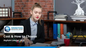 Woman reviewing documents at a desk under the title Asylum Lawyer 2026: Cost and How to Choose