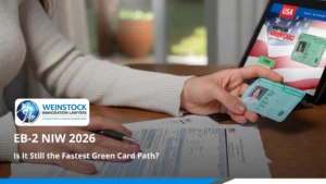 EB-2 NIW 2026 green card application — applicant holding permanent resident card with form