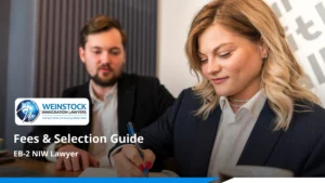 Two professionals at a desk with one taking notes under the title EB-2 NIW Lawyer: Fees and Selection Guide