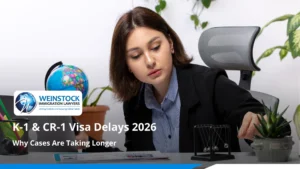 K-1 and CR-1 visa delays 2026 — applicant reviewing immigration paperwork at her desk